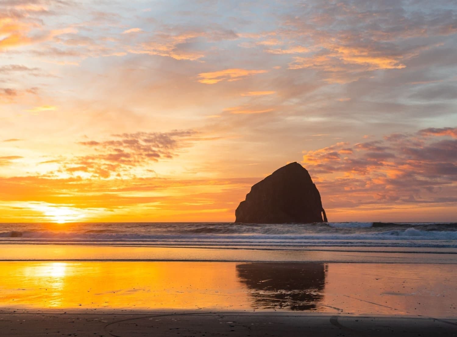 A sunset over the ocean and beach at Inn at Cape Kiwanda
