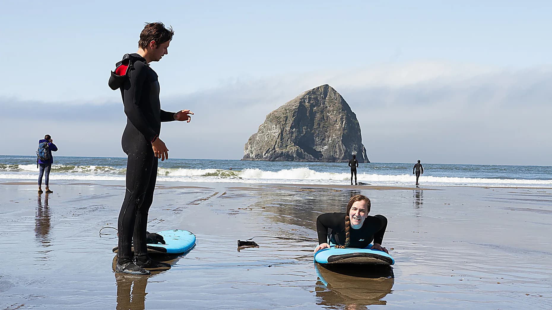 Surf instructor teaching pop-up technique on the beach at Cape Kiwanda, Pacific City, Oregon Coast
