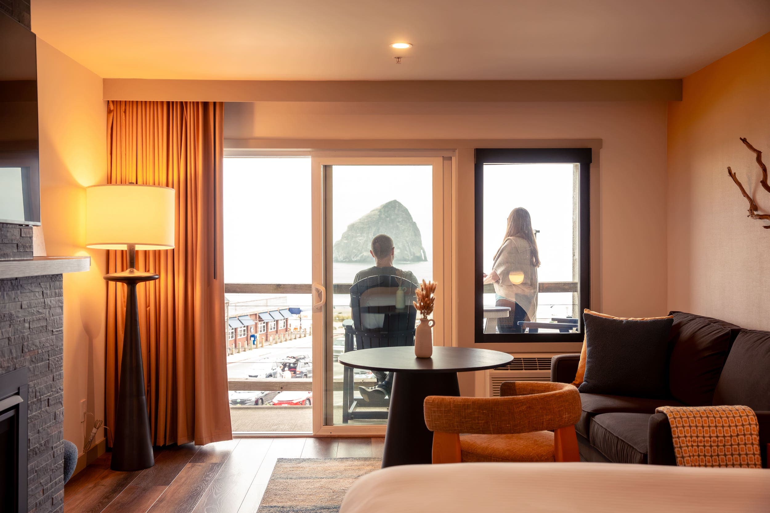 A couple sitting on the Balcony looking at the beach from their room at Inn at Cape Kiwanda