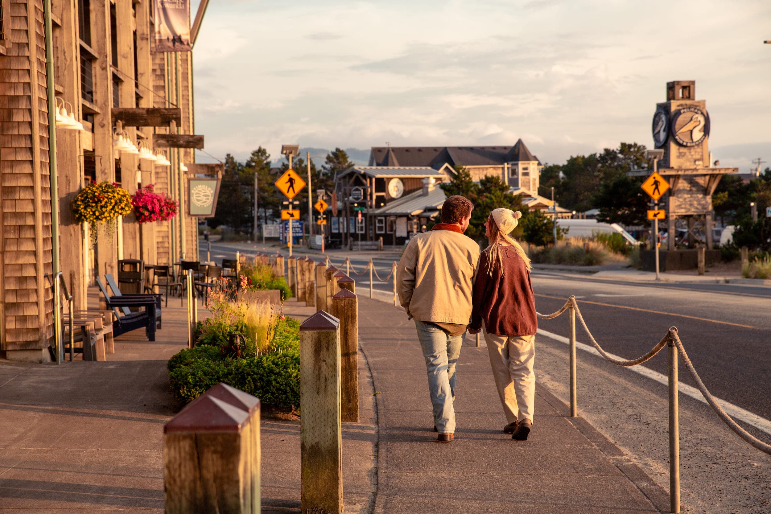 A couple walking down the sidewalk in Cape Kiwanda