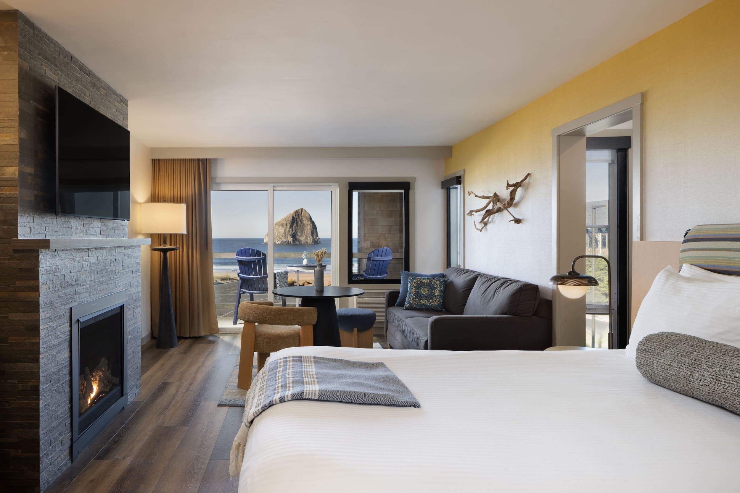 Inn At Cape Kiwanda Family Suite With Bunk Room with a fireplace, sitting area, and a balcony with a view of the beach