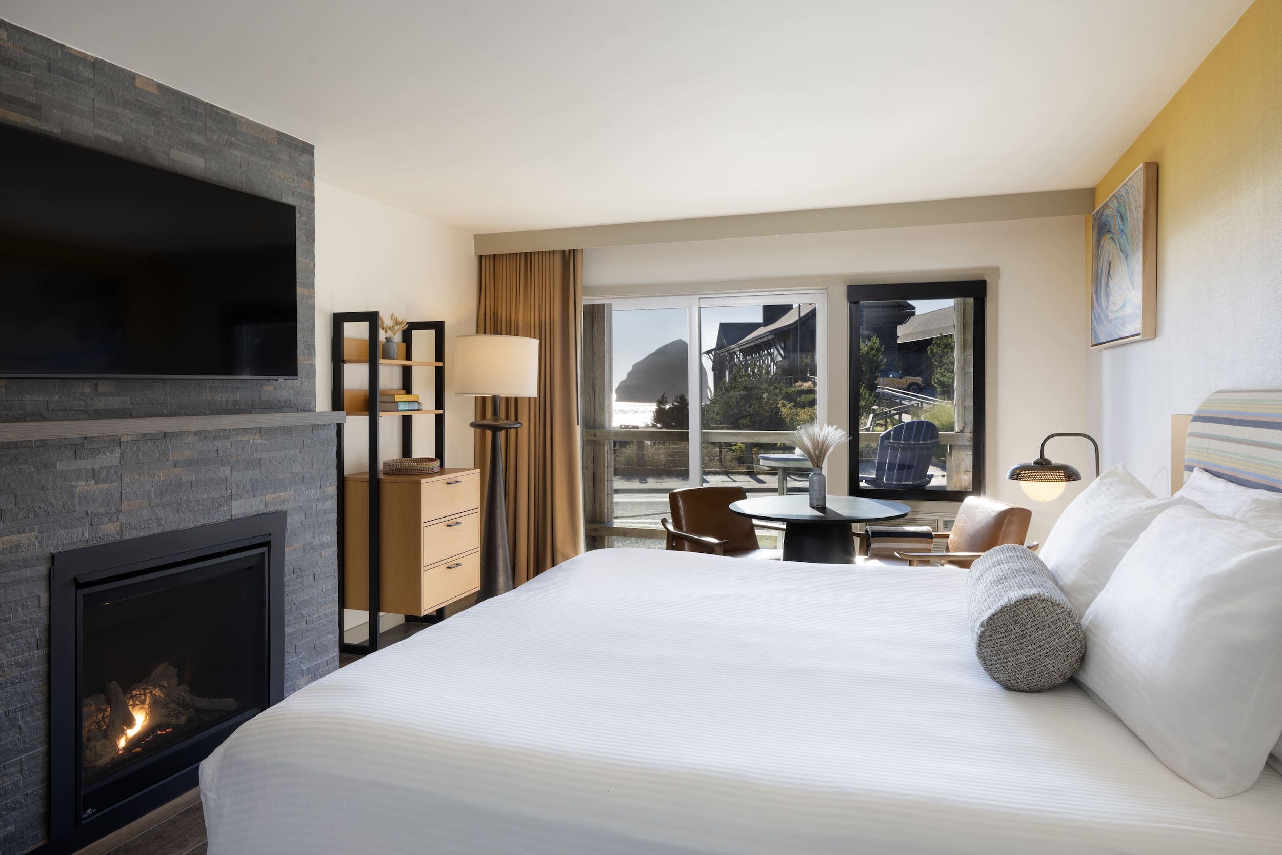 Inn At Cape Kiwanda Signature King Jetted Tub Partial View room with a king bed, fireplace, table and chairs, and balcony with a view of the ocean