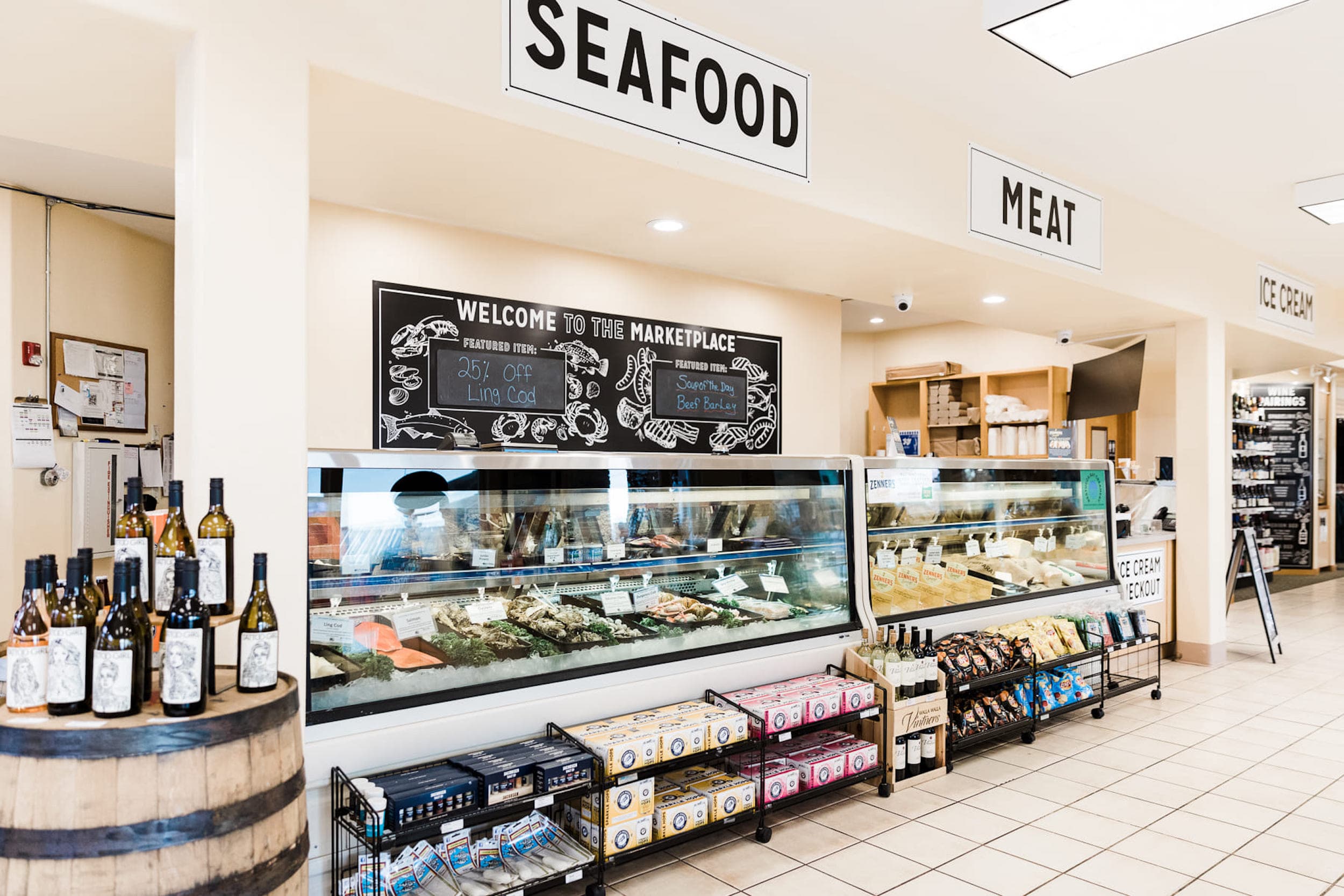 Inside the marketplace with sections of seafood, meat, and ice cream