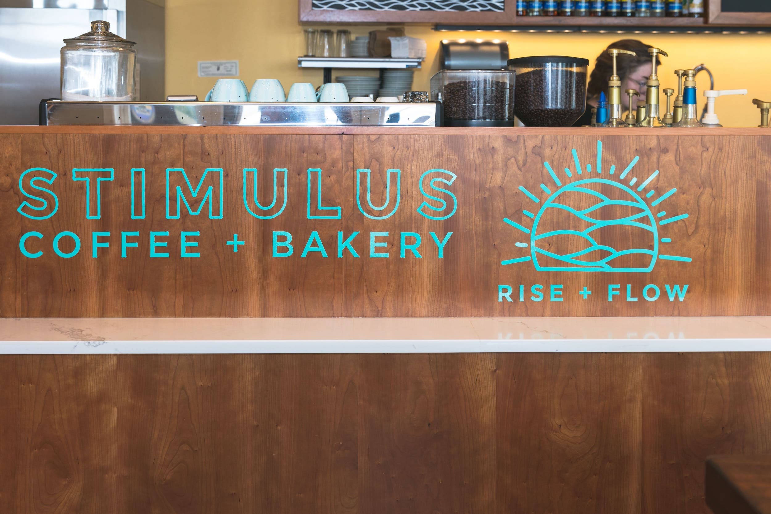 Stimulus coffee + bar counter with logo saying Rise + Flow