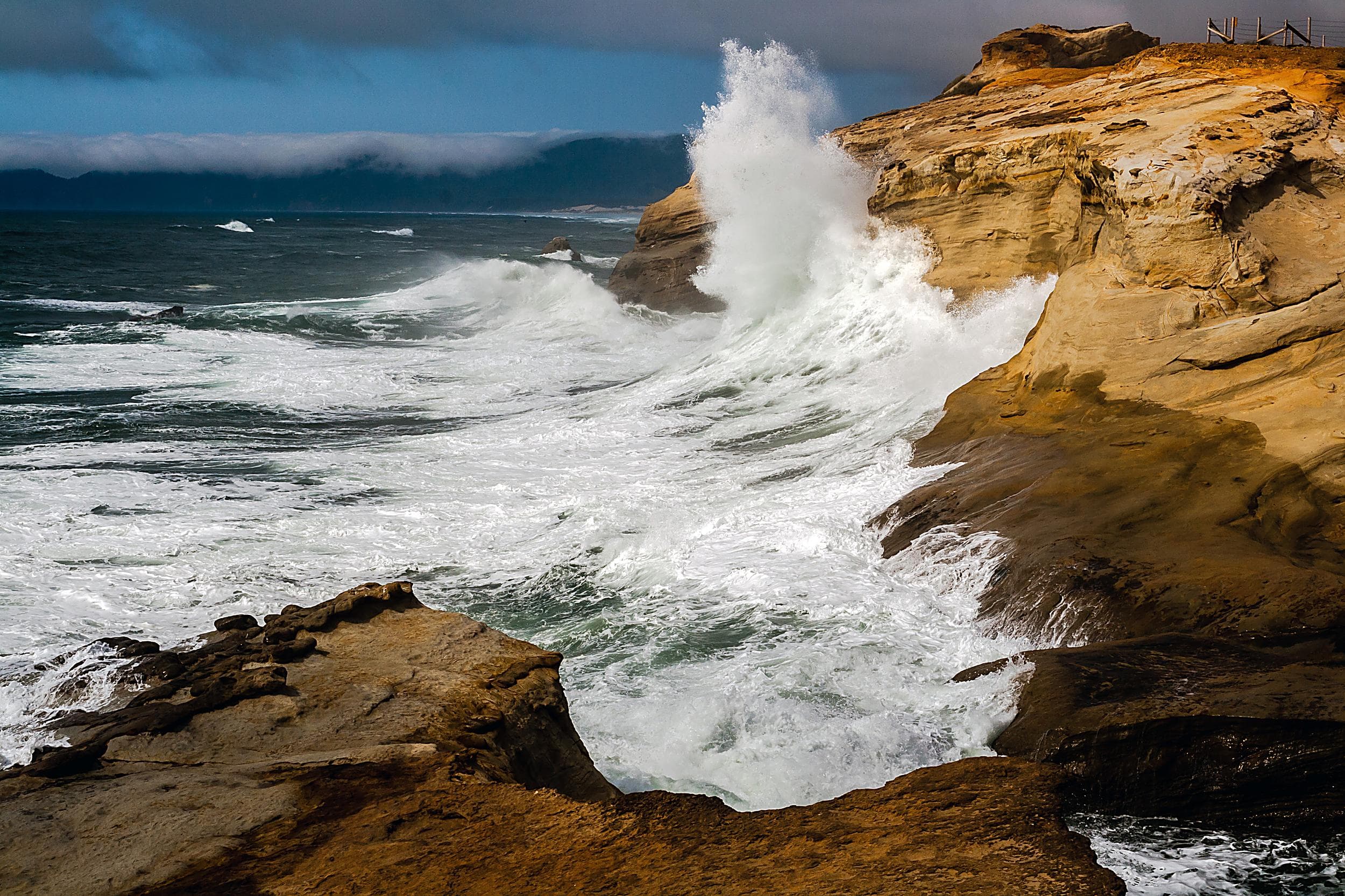 King tide waves crashing against sandstone cliffs at Cape Kiwanda near the Inn at Cape Kiwanda, Pacific City, Oregon Coast