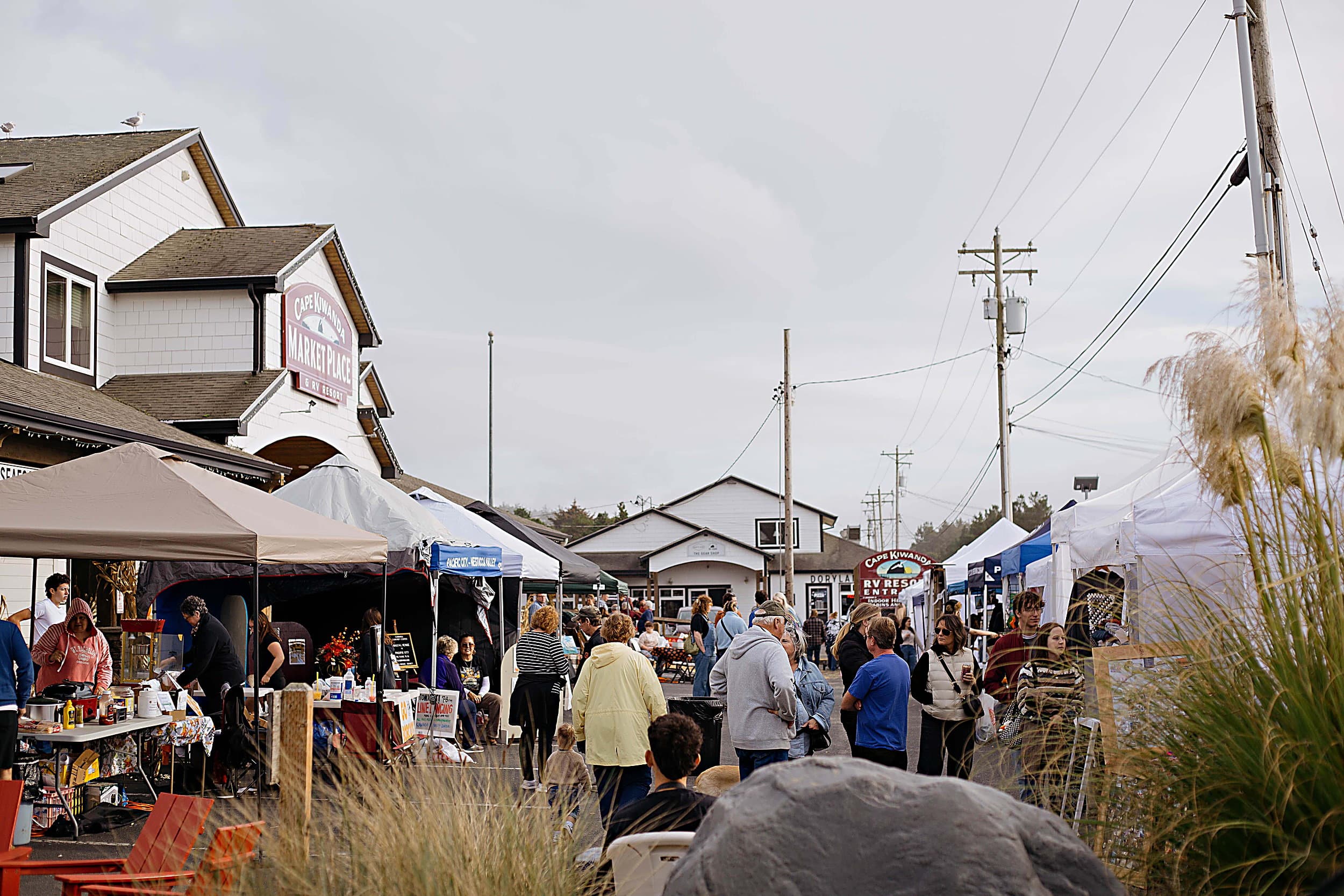 Crowds browsing vendor tents at the Fall Festival outside Cape Kiwanda Market Place, steps from the Inn at Cape Kiwanda, Pacific City, Oregon Coast
