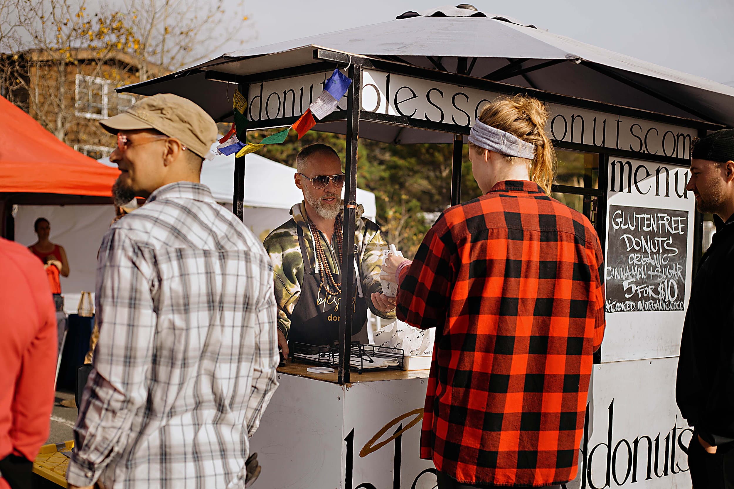 Visitors ordering gluten-free mini donuts from a food vendor at the Fall Festival, Cape Kiwanda, Pacific City, Oregon Coast