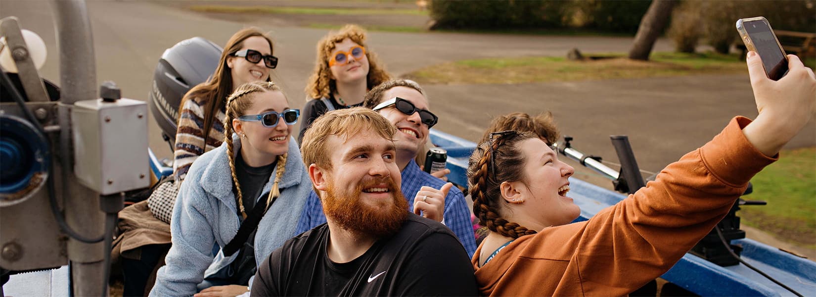 Friends taking a group selfie in a Pacific City dory boat at Hart's Camp near Cape Kiwanda, Oregon Coast