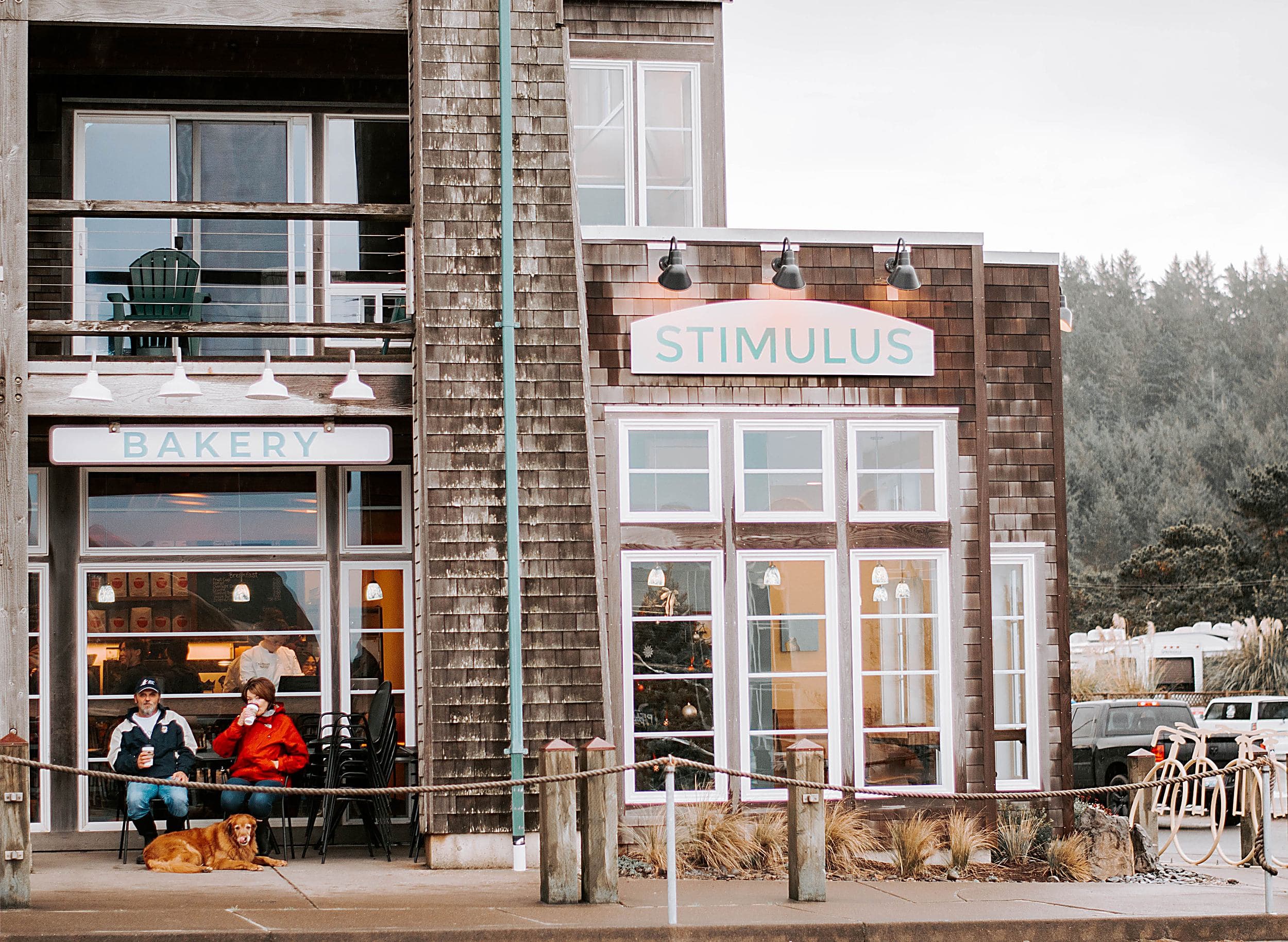 Guests and their dog outside Stimulus Coffee and Bakery across from the Inn at Cape Kiwanda in Pacific City, Oregon